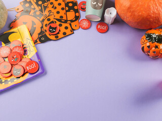 Halloween purple frame background flatlay with pumpkins and party decor