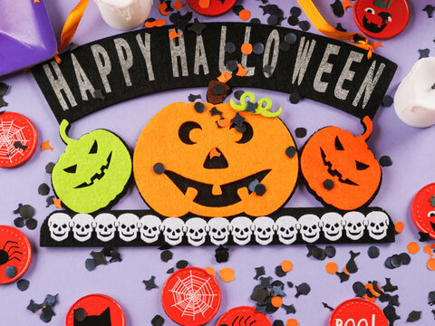 Happy halloween greetings decor with pumpkins on purple orange background