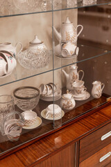 Elegant collection of vintage glassware and porcelain is carefully arranged in a wooden cabinet. Each piece reflects fine craftsmanship and timeless beauty. A perfect display for enthusiasts