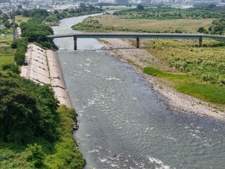A river with a bridge over it. The water is calm and clear