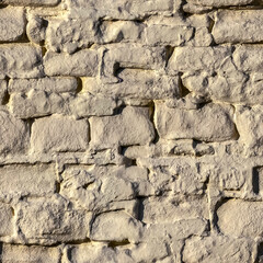 Seamless texture of an old brick wall painted beige
