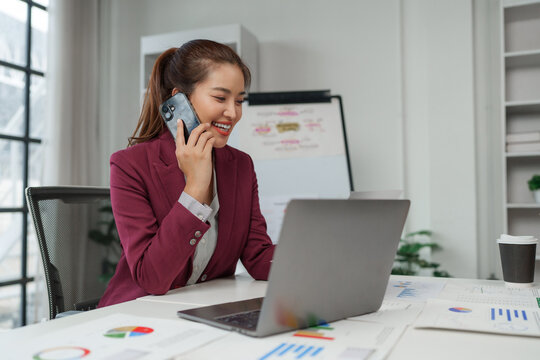 Businesswoman talking on phone managing financial data