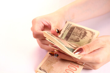 1万円札を数える女性の手
