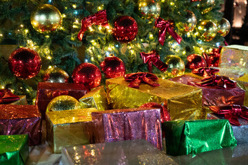 Christmas gifts tree. Colorful wrapped presents piled beneath a brightly illuminated festive fir...