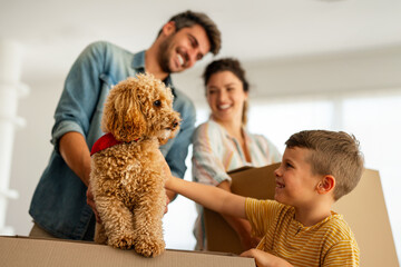 Happy family with cardboard boxes in new house at moving day. Mortgage, family, real estate concept