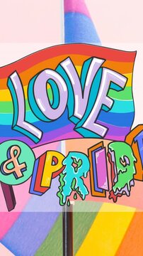 Animation of rainbow flags over midsection of lesbian couple drinking coffee