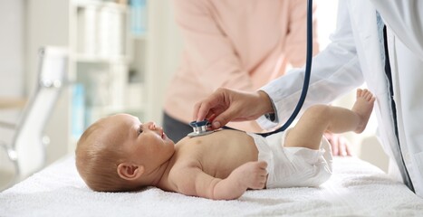 Obraz premium Mother and child having appointment with doctor. Pediatrician examining little baby with stethoscope in hospital, closeup