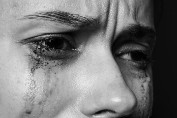 Naklejka premium Sad woman crying on dark background, closeup. Black and white effect