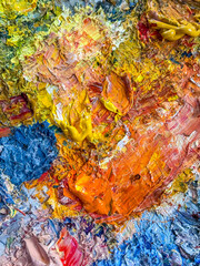 Close up of oil paint texture with dominant yellow and blue. Rich artistic background with vivid strokes.