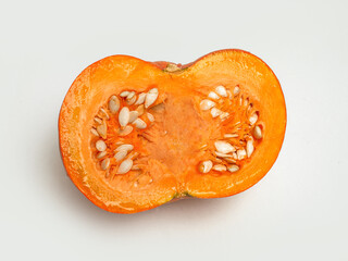 Cut pumpkin on white background. Fresh ingredient for autumn recipes.