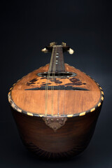 Mandolino vintage in legno su sfondo nero. Strumento musicale.