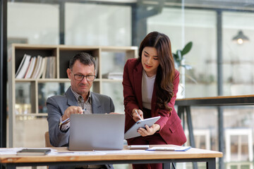 Business colleagues discussing project while using technology