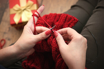 woman knitting with red wool
