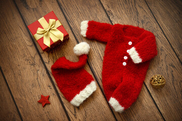 Christmas decoration and hand knit baby clothes on wooden background