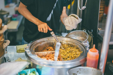 Vendor preparing Taiwanese street food at a local market stall

