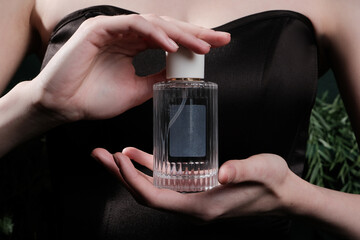 Graceful hands holding a luxurious perfume bottle. In the photo, beautiful female hands are holding...
