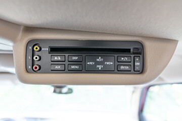 Overhead DVD player control panel inside a 2004 American 4x4 family SUV showing AUX video and audio inputs, playback buttons, and display controls in beige roof interior car design detail