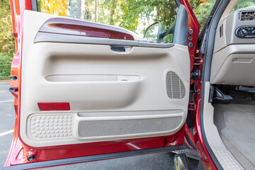 Interior photo of an older 2004 American 4x4 family suv truck highlighting clean and well-preserved beige color cabin details, speakers, door window power switches  
