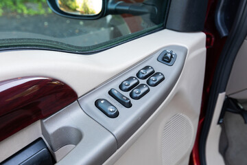 Interior photo of an older 2004 American 4x4 family suv truck highlighting clean and well-preserved beige color cabin details, speakers, door window power switches  