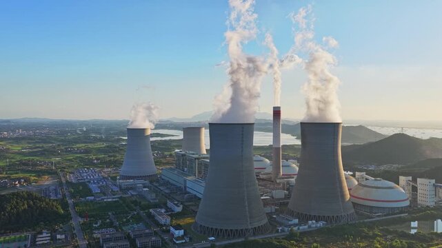 Aerial view of a thermal power plant and cooling towers at sunset