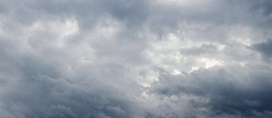 Fototapeta premium A cluster of dark gray storm clouds in the sky before rain, a dramatic background symbolizing bad weather, storm, rain, gloomy mood
