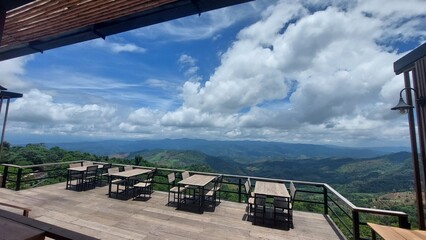 Fototapeta premium Scenic mountain view cafe with wooden tables and open terrace