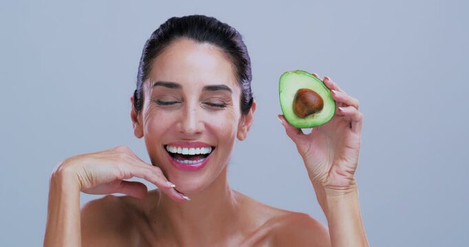 Face, avocado and woman in studio, skincare and dermatology on white background. Space, natural cosmetics and mature person with smile, facial beauty and detox with omega 3 treatment and nutrition