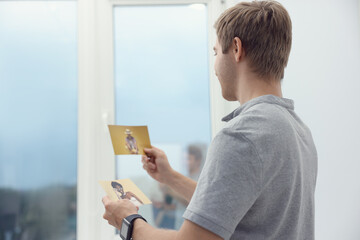Professional photographer with photos near window in studio, space for text
