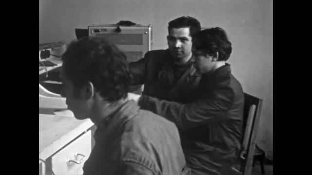 Cheerful young people gather, brainstorming and working together with bright smiles and lively talking. Teamwork, cooperation turn ideas into action. Old film. Archival retro 1960s. Vintage archive