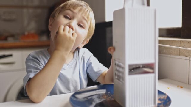 Blond little boy grating and eating chocolate