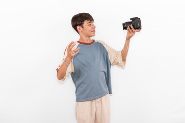 young casual dressed Generation Z white male model teenage boy selfie photo with DSLR camera. happy smile expressing joy in positive happy way in plain background studio setting