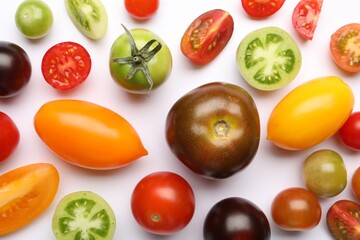 Ripe colorful tomatoes on white background, flat lay