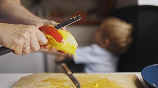 Mother peeling a fresh ripe mango for her child
