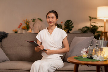 Asian adult woman spa therapist professional holding clipboard for client consultation promoting wellness relaxation luxury services in serene lounge