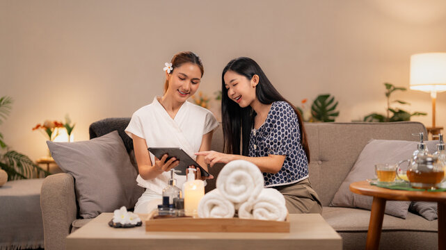 Asian spa therapist client review wellness treatments digital tablet consultation serene lounge experience