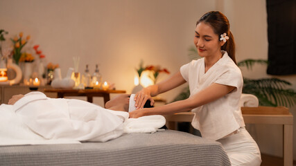 Asian adult woman therapist provides relaxing facial massage adult man client tranquil spa retreat