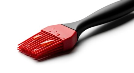 A red silicone basting brush with oil drops on a white background, perfect for cooking and baking.