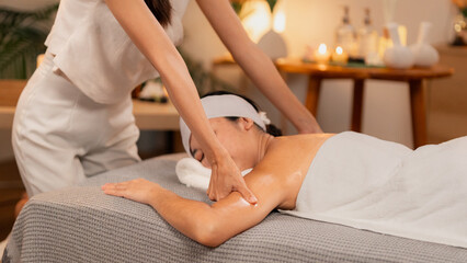 Fototapeta premium Asian Woman Enjoying Relaxing Spa Arm Shoulder Massage Professional Therapist Providing Soothing Treatment Wellness Center Tranquil Environment Body Care