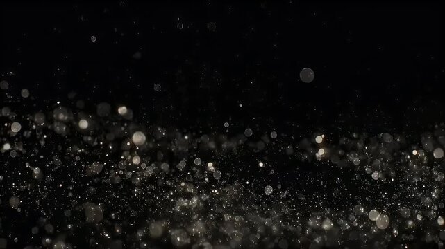 Floating orbs and specs of light drift against a black, abstract background