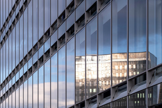 Corporate architecture with mirrored surfaces reflecting sunlight on urban structures showing balance between economy, design, and technological progress