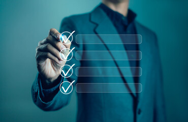 Businessman marks digital checklist with check mark symbol, signifying work completion, efficiency, project management and planning in modern business concept.