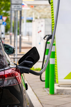 Electric car connected to green energy charging station in Frankfurt emphasizing urban sustainability, renewable transportation, and modern clean technology integration in public space
