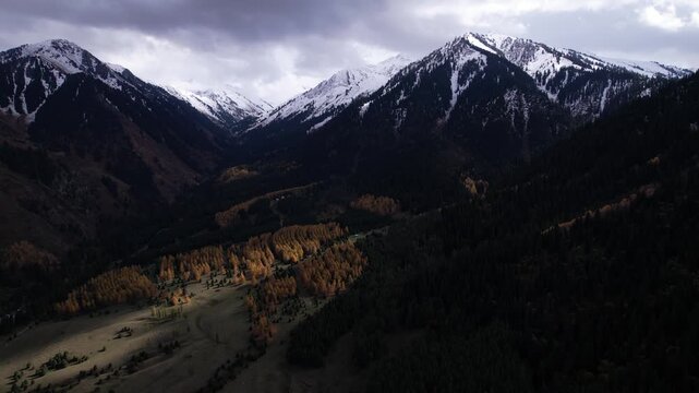 Breathtaking Aerial Views of Majestic Snow-Capped Mountains and Lush Forests Reflecting the Beauty of Natural Landscapes in Autumn.