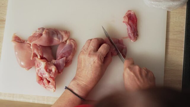 Expert chef prepares chicken for a delicious meal in a well-lit kitchen