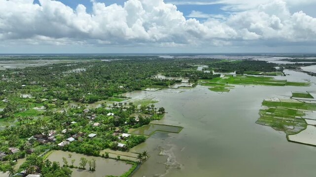 Aerial view of severe flooding, submerged homes, roads, and agricultural fields caused by collapse of river embankment due to strong tidal surge, Satkhira coastal region, Bangladesh