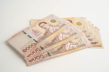 Asian woman counting Thai baht banknote money and holding in hand isolated on white background.