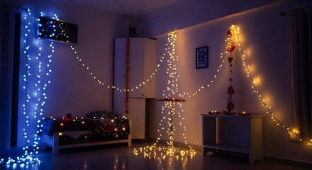 Cozy room decorated with glowing blue and yellow string lights and traditional diyas for a festive celebration.