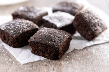 Homemade chocolate brownies with sugar powder on wooden table