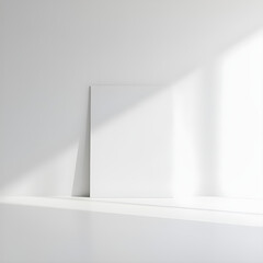Blank White Vertical Poster or Canvas Mockup Leaning on White Wall with Sunlight and Shadow