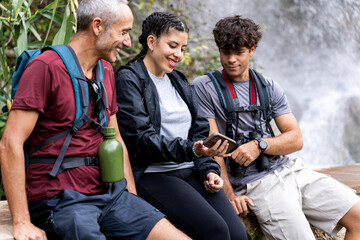 Family sharing smartphone during autumn trekking